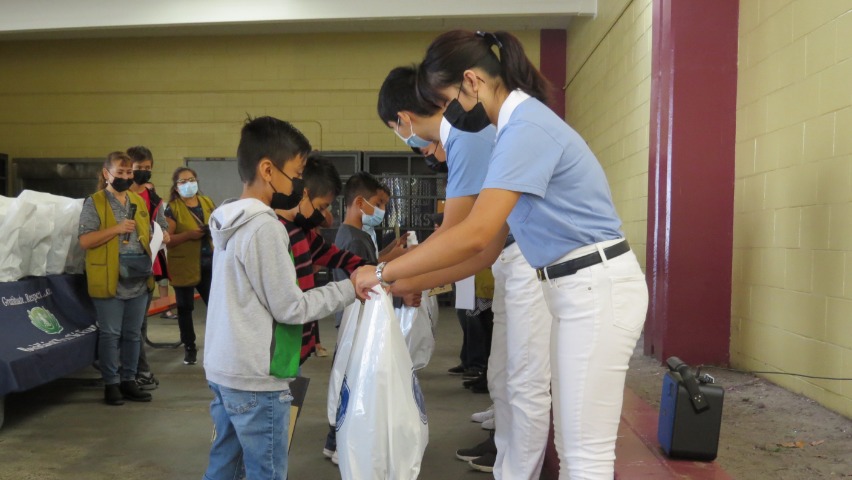 Los jóvenes voluntarios de Tzu Chi donan uniformes a los estudiantes. Foto/Chien-Chyun Harley Lee
