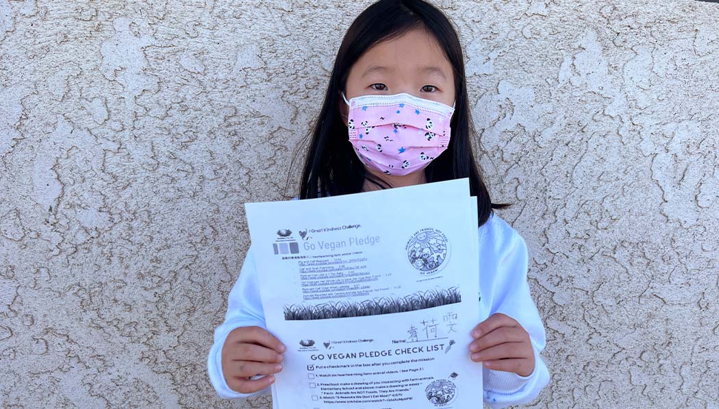 Tzu Chi Education Foundation holding her Go Vegan Pledge check list