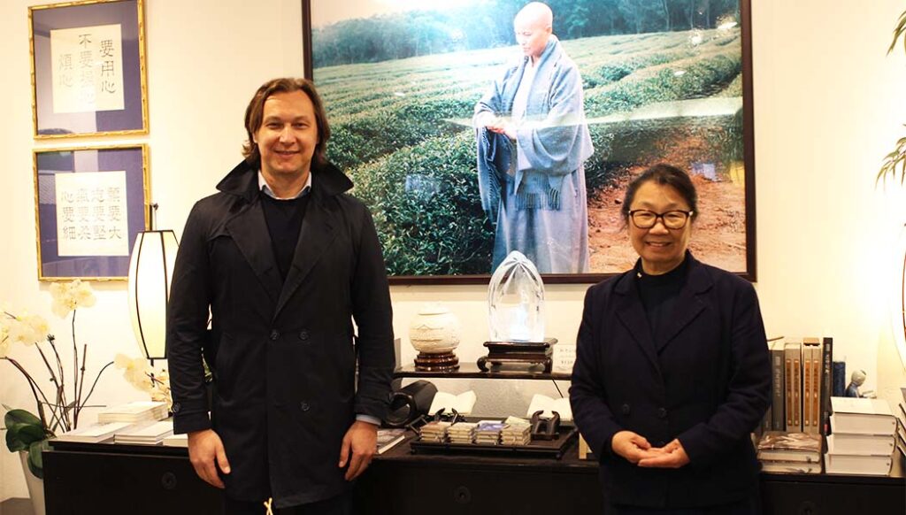 Alex Balint and Tzu Chi USA CEO  in front of Master Cheng Yen's photo