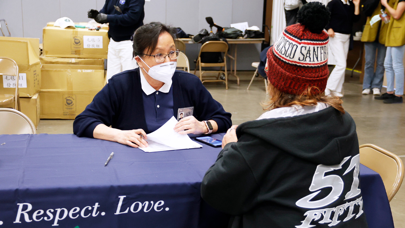 Tzu Chi volunteer distributing cash card for the recipient in Merced County