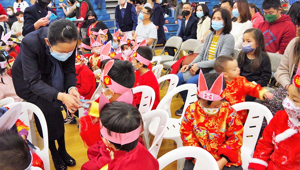 Tzu Chi Academy CEO distributing Hui fu red envelope to the students