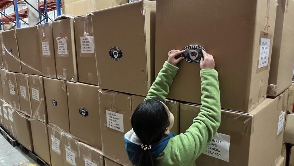 Tzu Chi volunteer labeling sticker on the supplies cartons