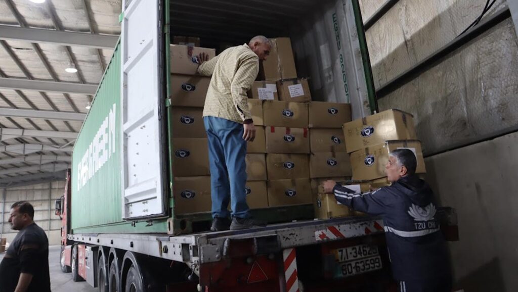 Volunteers unload supplies that arrive at the Jordan Hashemite Charity Organisation warehouse
