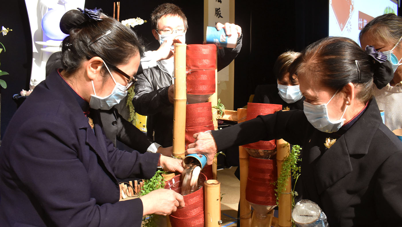 Tzu Chi members donating their Bamboo Bank money into the blessing pot