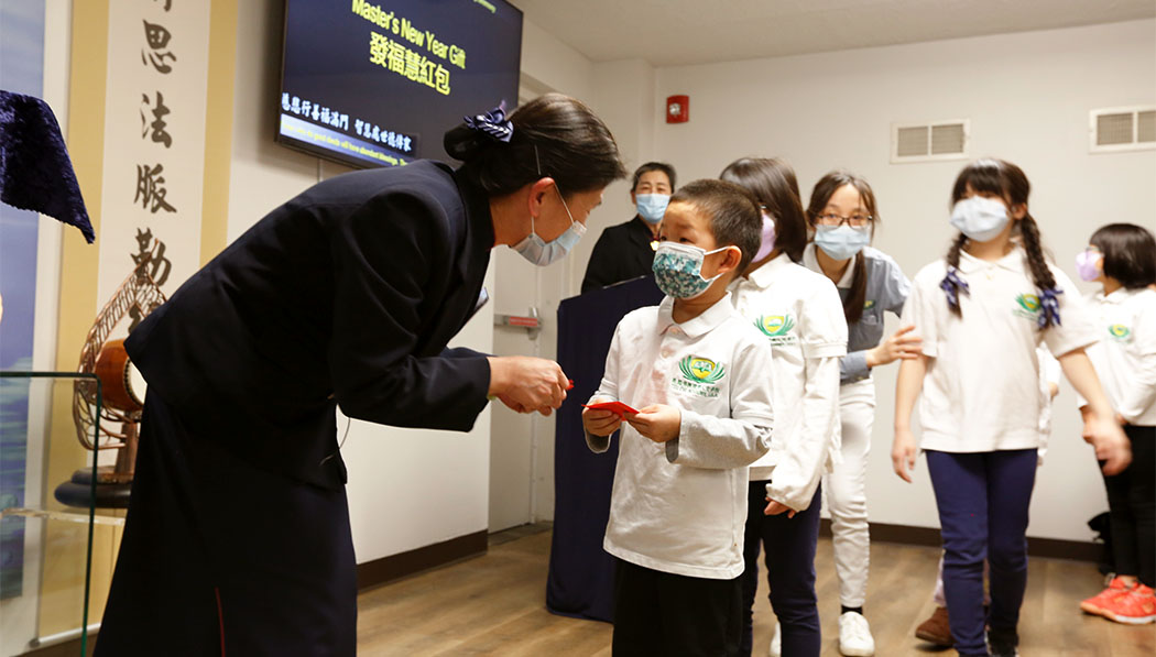 Tzu Chi Mid-Atlantic Region CEO distributing blessing red envelope to the Academy students
