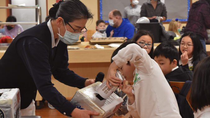 Tzu Chi Pittsburgh Academy student donating money from their Bamboo Bank