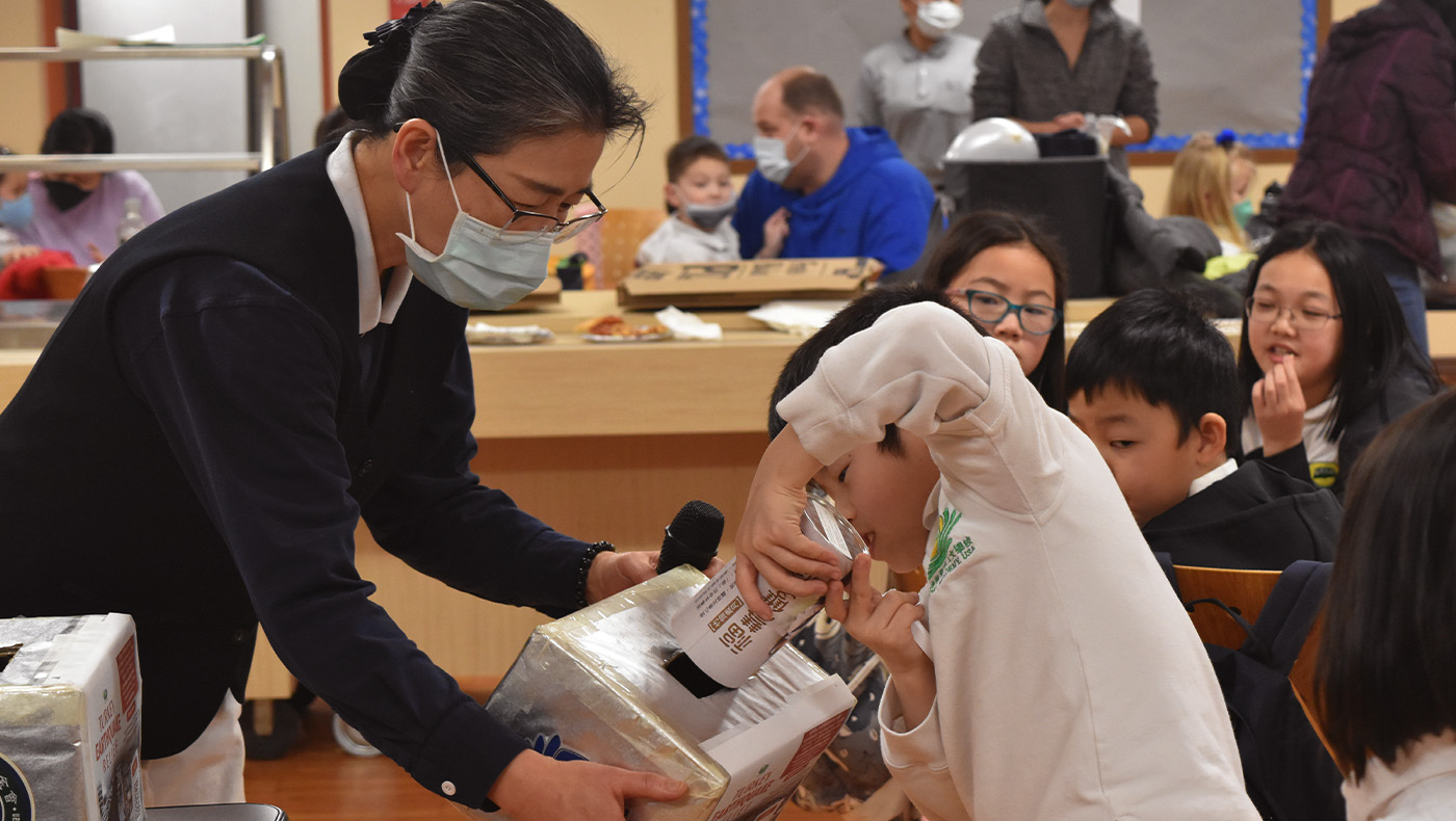 Tzu Chi Pittsburgh Academy student donating money from their Bamboo Bank
