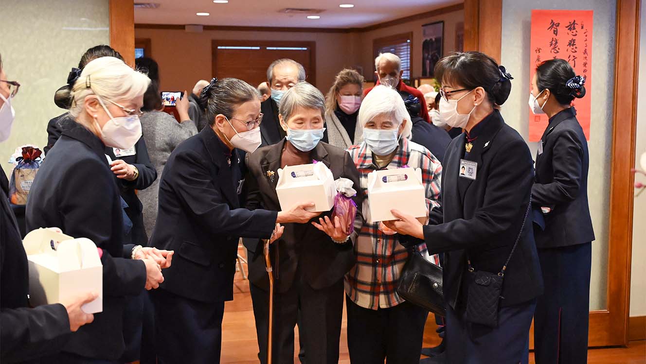 Tzu Chi volunteers distributing Fuhui pouch and desserts the guests