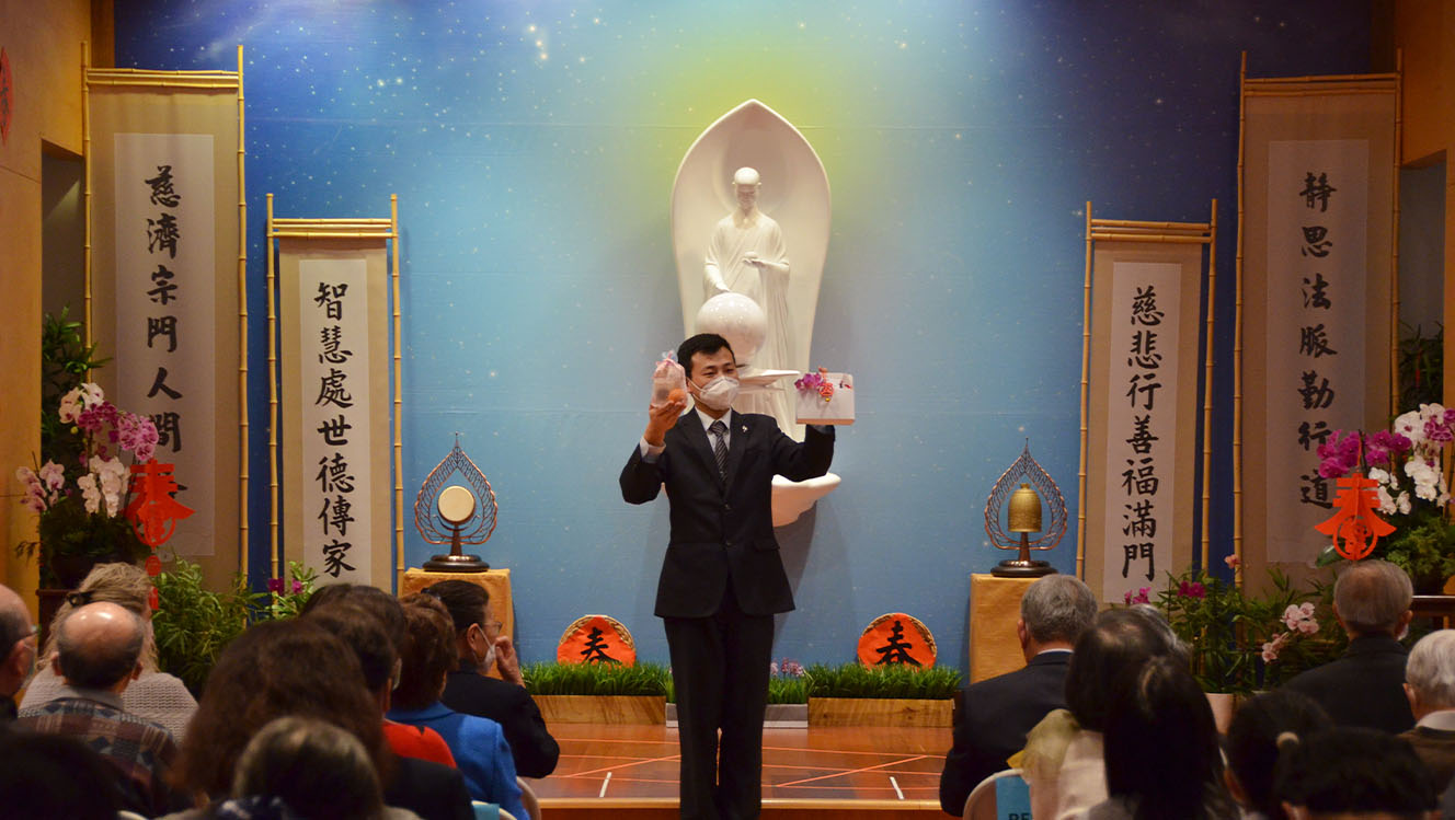 Tzu Chi Midwest Region volunteer introducing Fuhui pouch and the so