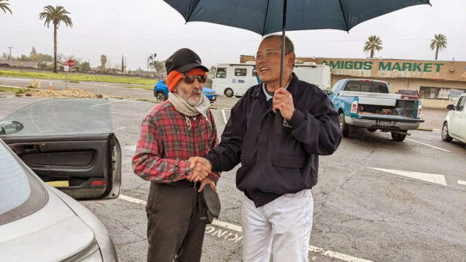 Tzu Chi volunteer and the Merced County flooding affected people holding hand