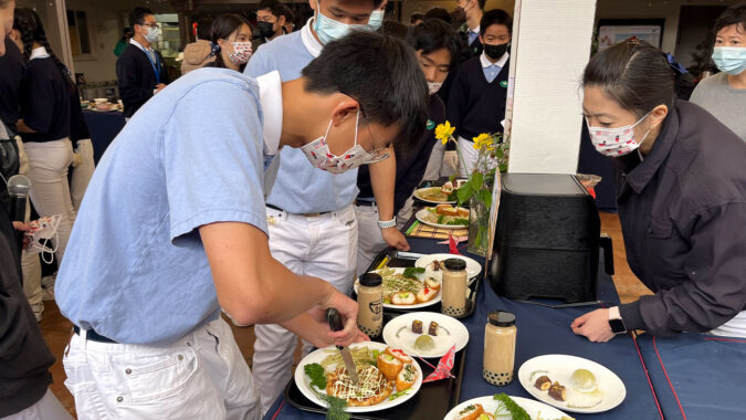 Tzu Chao cutting their handmade Okonomiyaki