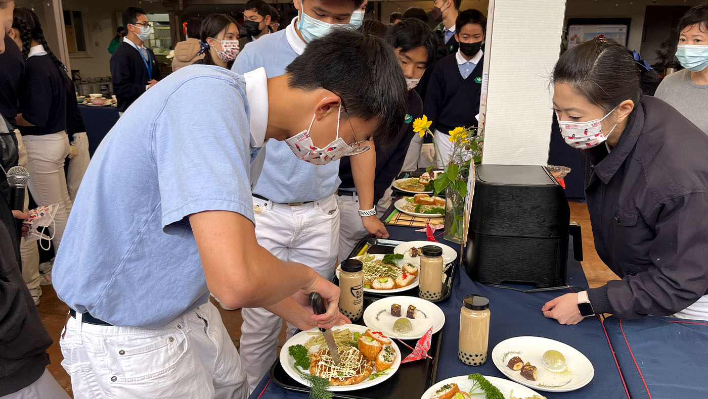 Tzu Chao cutting their handmade Okonomiyaki