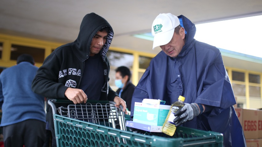 Voluntarios de Tzu Chi llegan a la despensa de alimentos a las 7:30 de la mañana y con el clima lluvioso organizan lo necesario para el evento. Foto/ Steven Chiu
