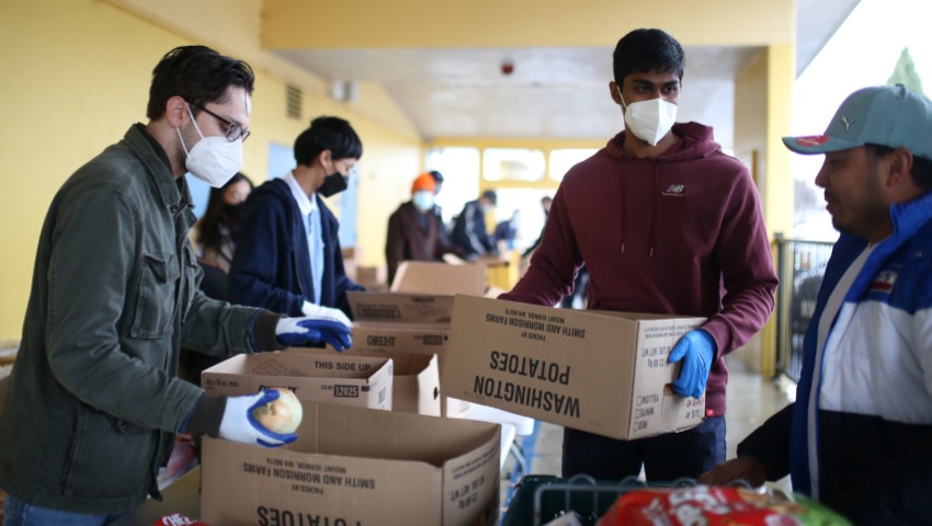 Young volunteers Praful and Nicholas are busy packing and distributing the food delivered by the food bank. Photo/ Steven Chiu
