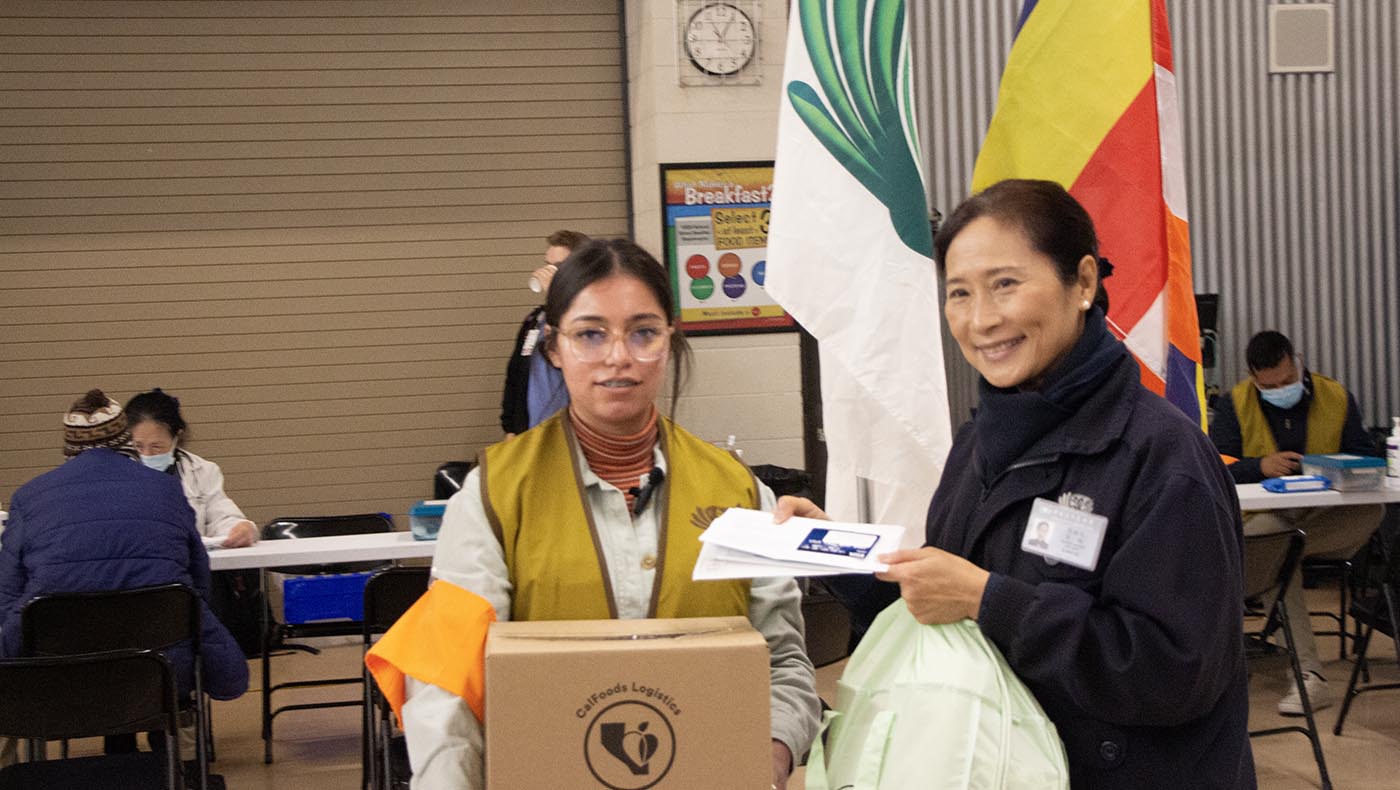 Voluntarios de Inland presentan a la ganadora de la beca, Karina Ibam, con una tarjeta prepagada, ropa y alimentos en nombre de Tzu Chi. Foto/Hongli Cai