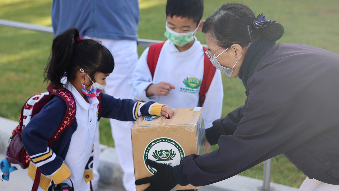 Tzu Chi Irvine Academy student putting money in donation box