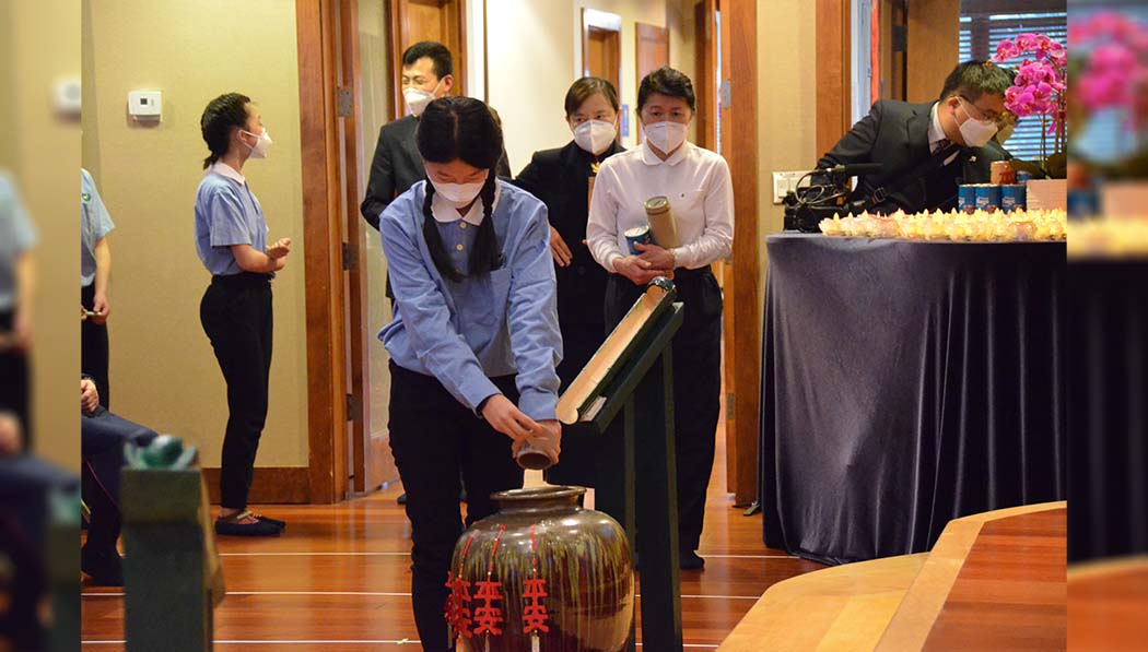 The guests pour the coins they saved daily in their bamboo banks into the “big fortune” urn. Photography/Jun Zhi Lin
