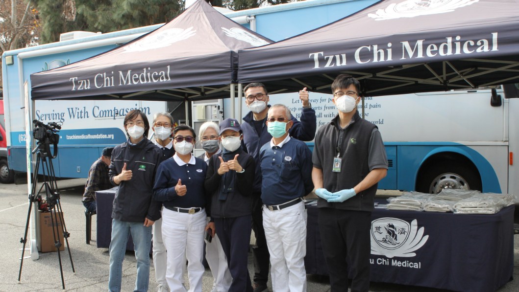 Los voluntarios posan en una foto de grupo delante de la Clínica Móvil para conmemorar su participación. Foto/Jennifer Chien