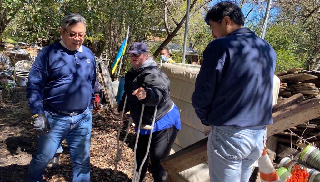 Tzu Chi volunteers visit the home of flood survivor Lorraine (center) to help clean up her home