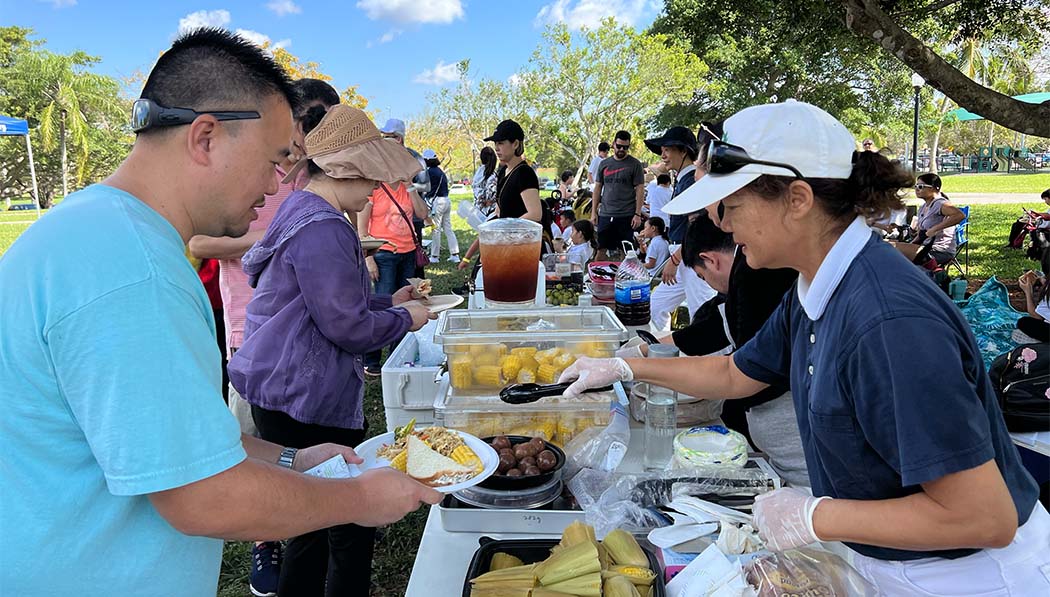 Tzu Chi Miami Academy students and parents enjoying vegetarian food prepared by volunteers
