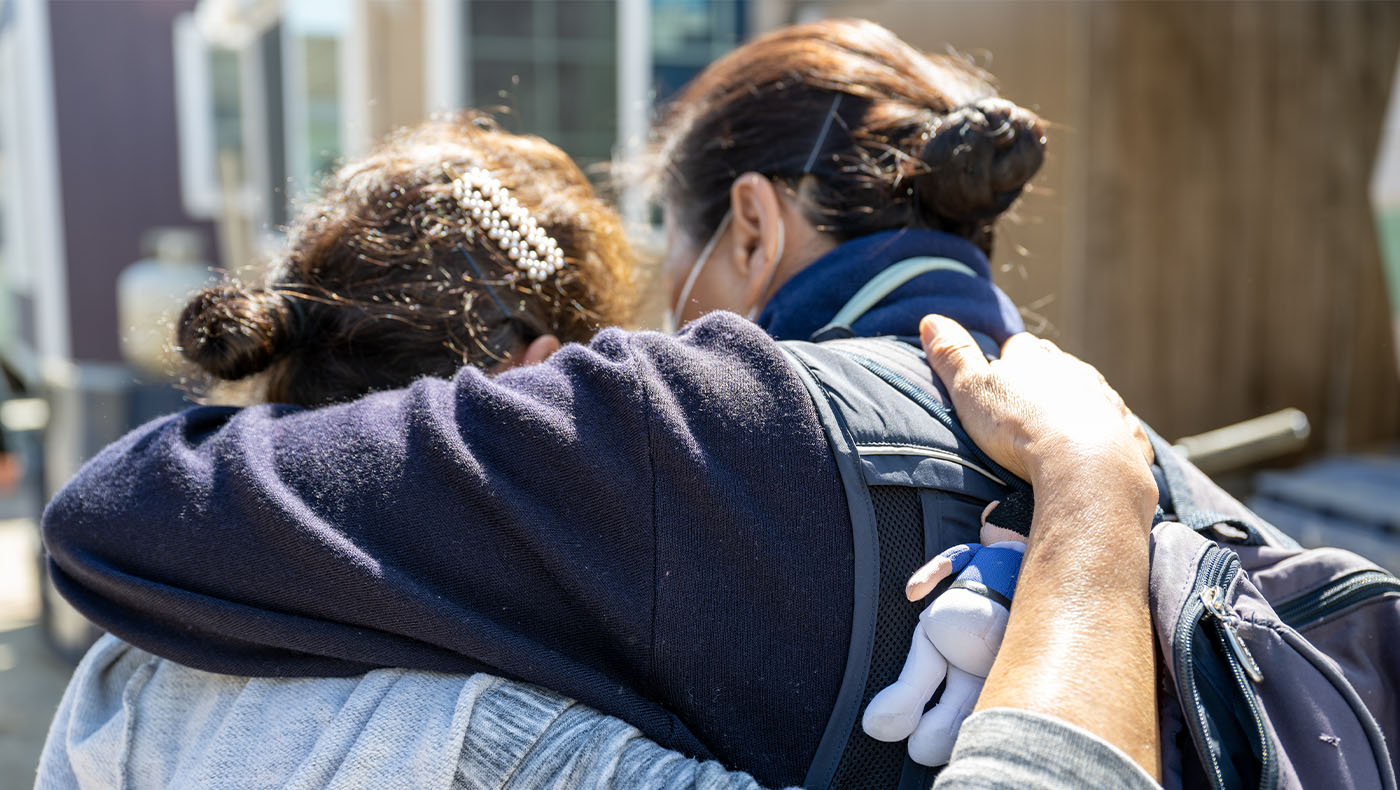 The back of Tzu Chi volunteer and Pajaro Flood survivor embracing each other