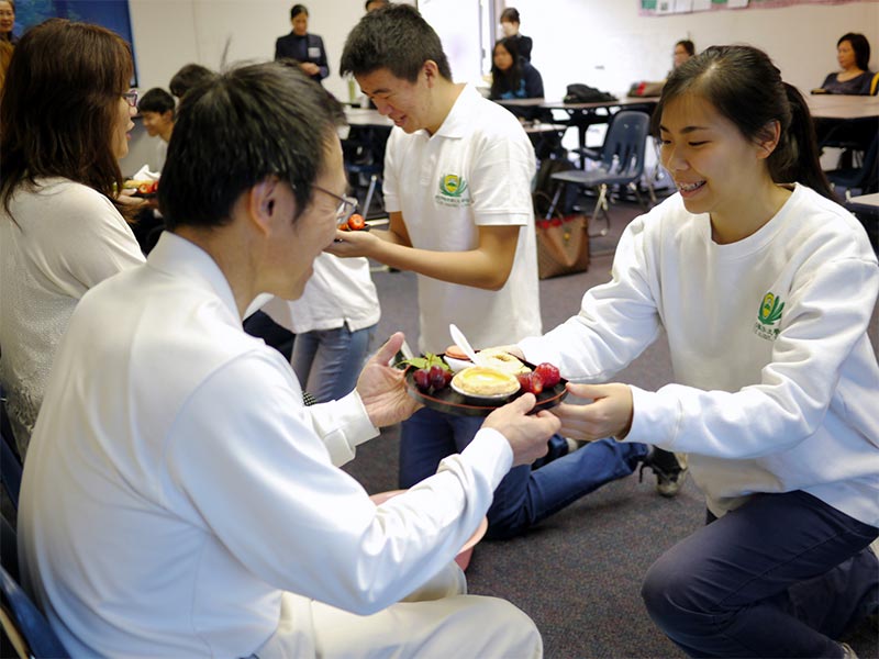 The student in Tzu Chi Academy serve tea to the parents