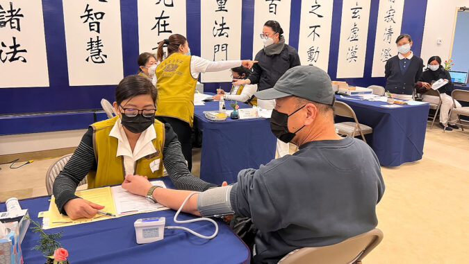 Tzu Chi volunteer checking blood pressure for the vistor