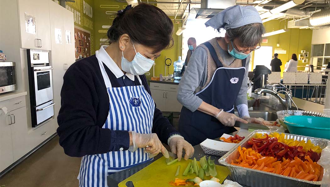 Voluntarios de Tzu Chi preparando platos vegetarianos y refrigerios para el personal. Foto/Huiqing Su