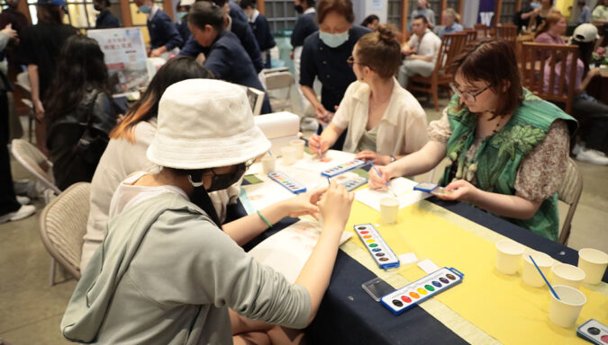 Volunteers and visitors painting with gouache