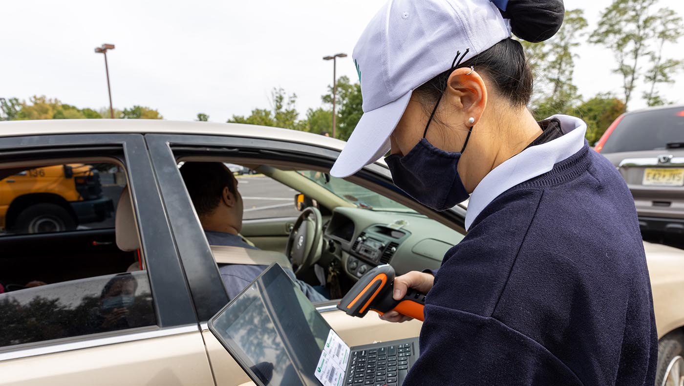 As people arrive at the Mid-Atlantic Region Office for its food pantry program, Tzu Chi volunteers scan QR codes to confirm their identities, then load the food in the cars without needing people to leave their vehicles, completing the distribution process in just a few minutes. Photo/Wankang Wang