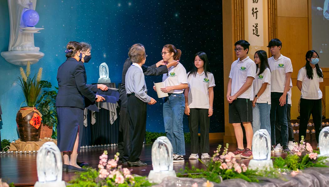 Tzu Chi Houston Academy student receiving graduation certification on the stage