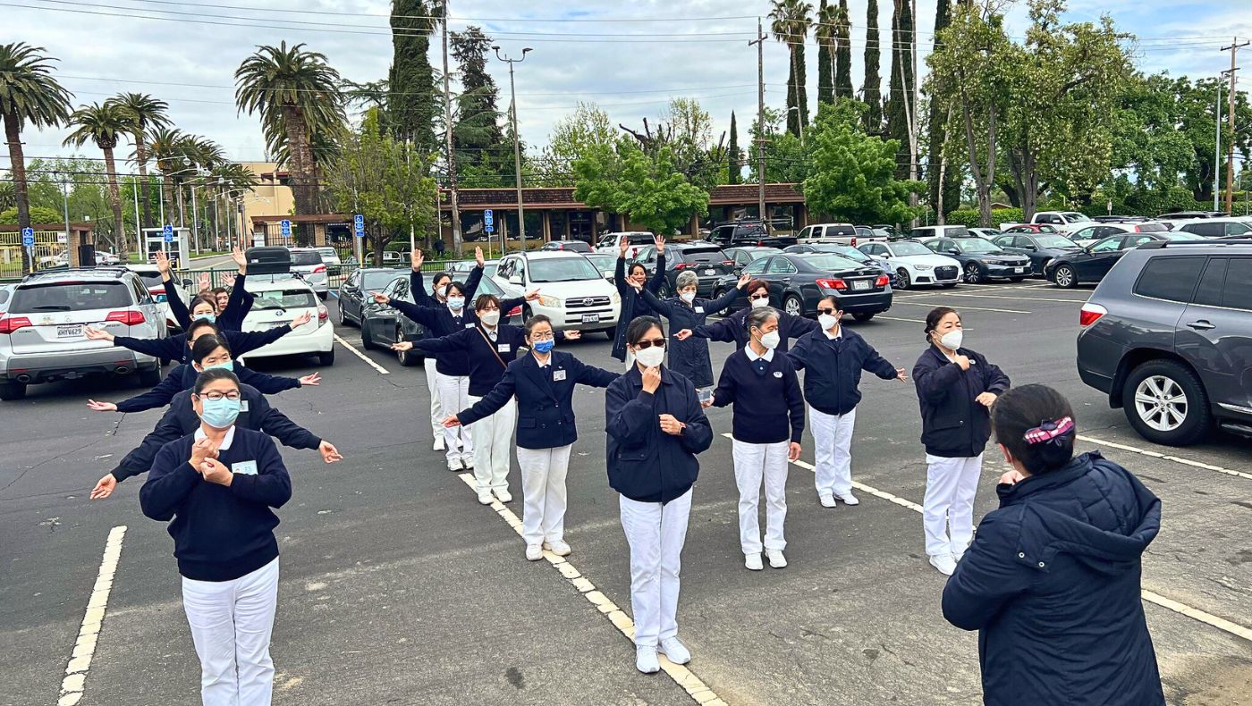 Tzu Chi volunteers gather early in the morning in the parking lot to rehearse their sign language song. Photo/Jiaxing Chen