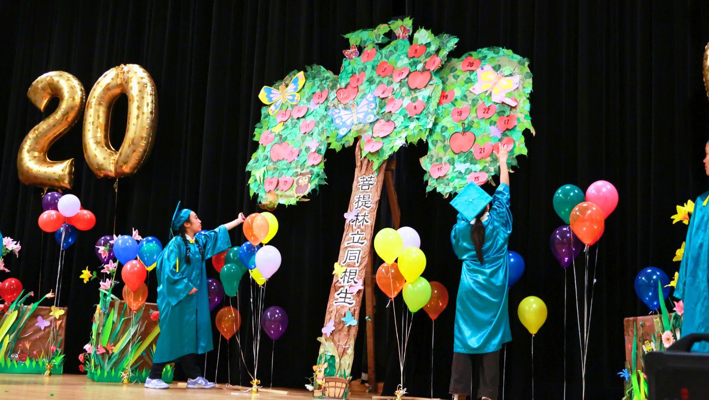 兩屆的畢業生代表在菩提樹上貼上蘋果。攝影／駱淑麗