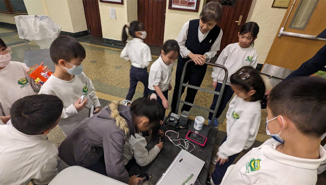 Estudiantes entregan sus dispositivos electrónicos. Algunos se muestran tristes. Foto/ Cortesía de la Oficina de Tzu Chi en Long Island.