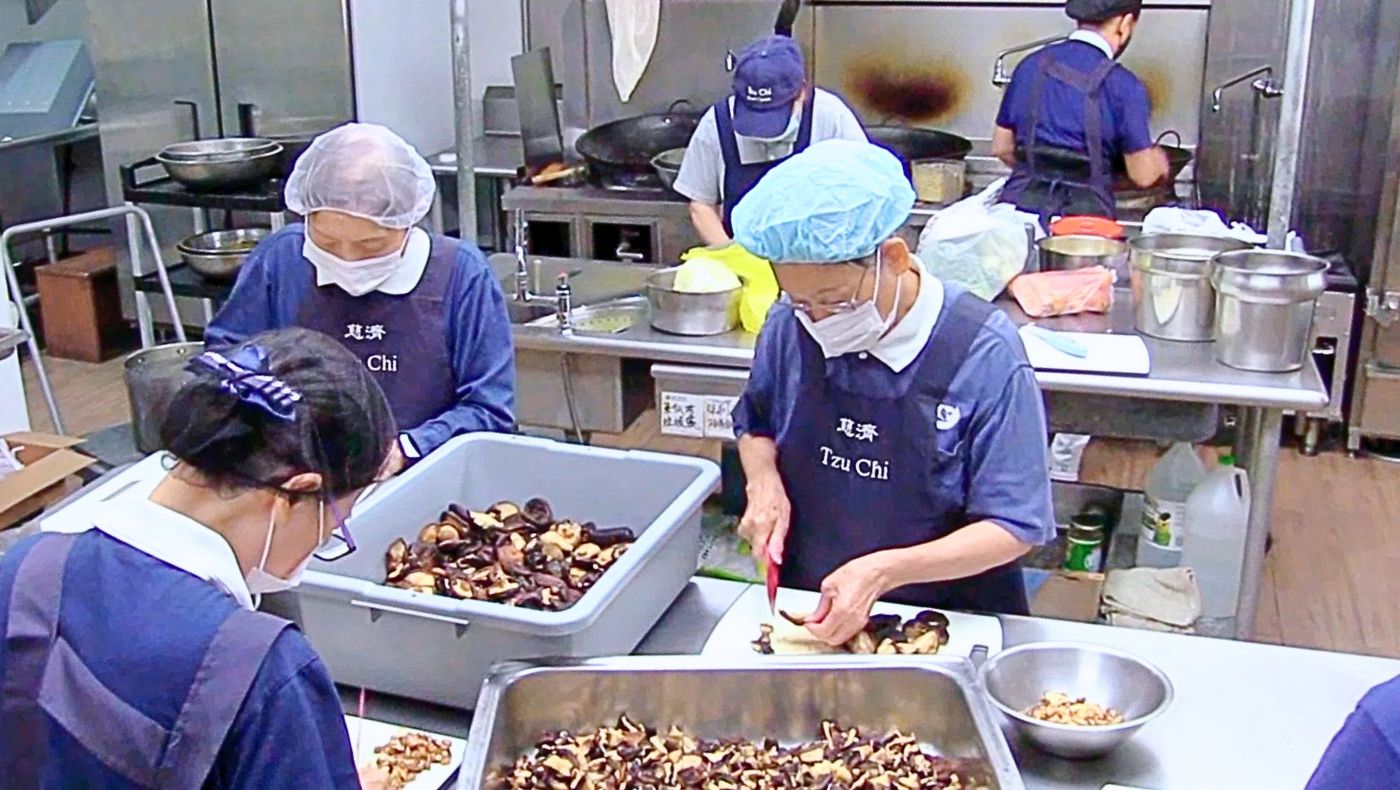 志工將蘑菇和蘿蔔幹等素餡食材切碎。攝影／關爾