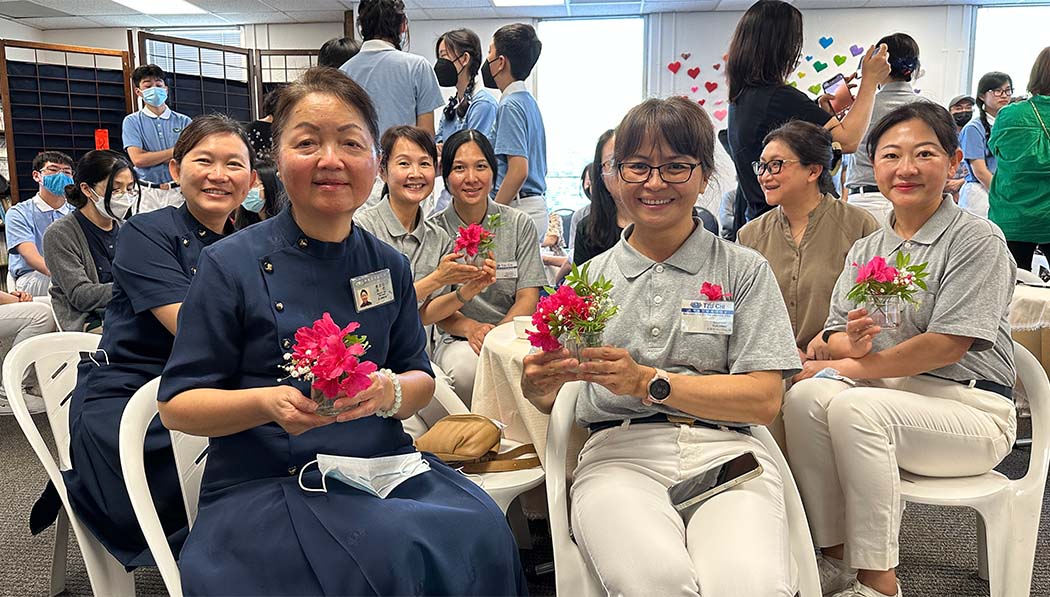 Tzu Chi volunteers holding flowers