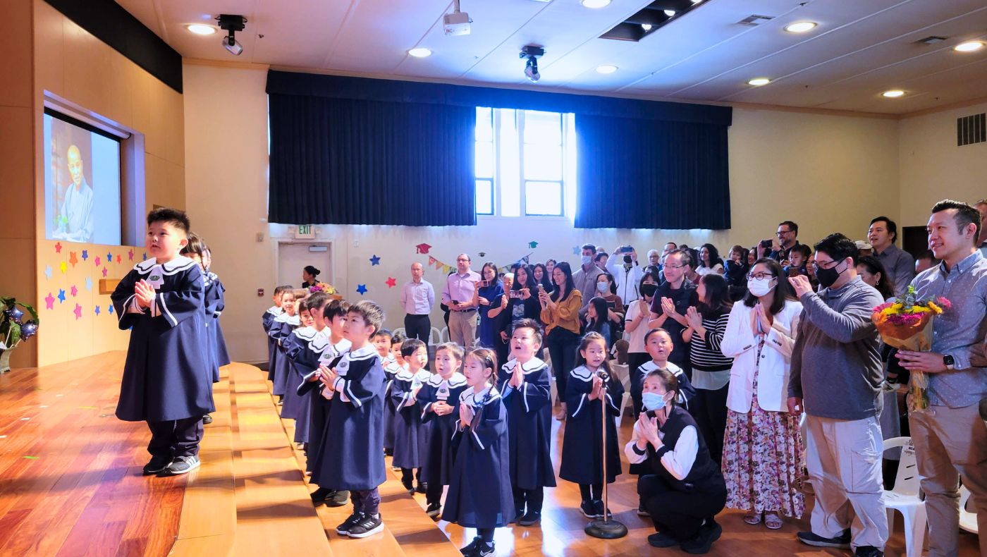 Los Niños, junto con sus padres e invitados en la audiencia, unen sus manos en un gesto de oración y realizan las tres reverencias tradicionales como señal de respeto. Foto/Ihsuan Tsai
