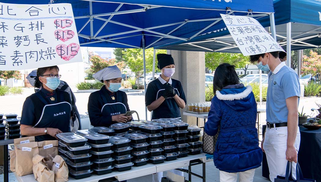 Voluntarios preparan una variedad de deliciosa comida vegetariana, que es muy popular en el puesto de venta de caridad. Foto/Mimi Ching