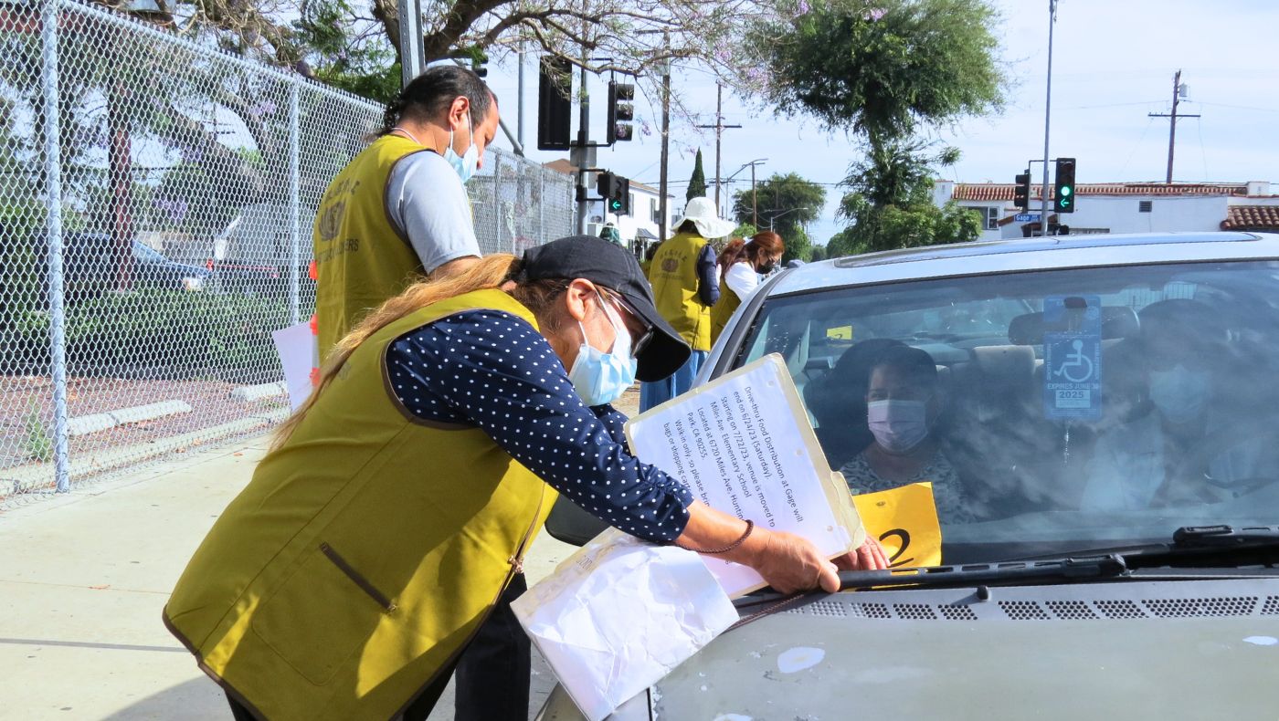 Volunteers put number tags on the vehicles after they complete registration