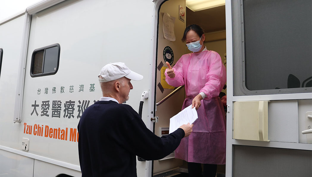 Tzu Chi volunteers giving thumps up from the DAAI mobile dental clinic