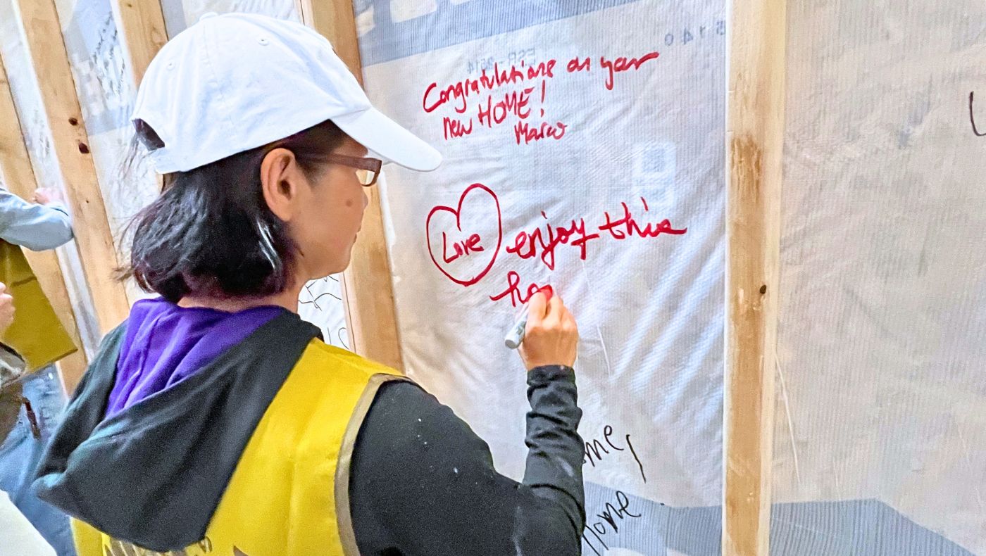 Volunteer writing blessing message on the wall