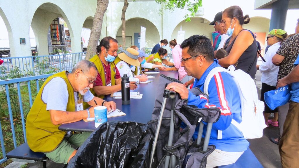 Residents complete government-required registration forms with the help of volunteers.