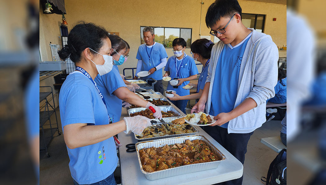 慈濟美國教育基金會執行長李瓊薰為孩子們分菜。攝影／黃旭睦