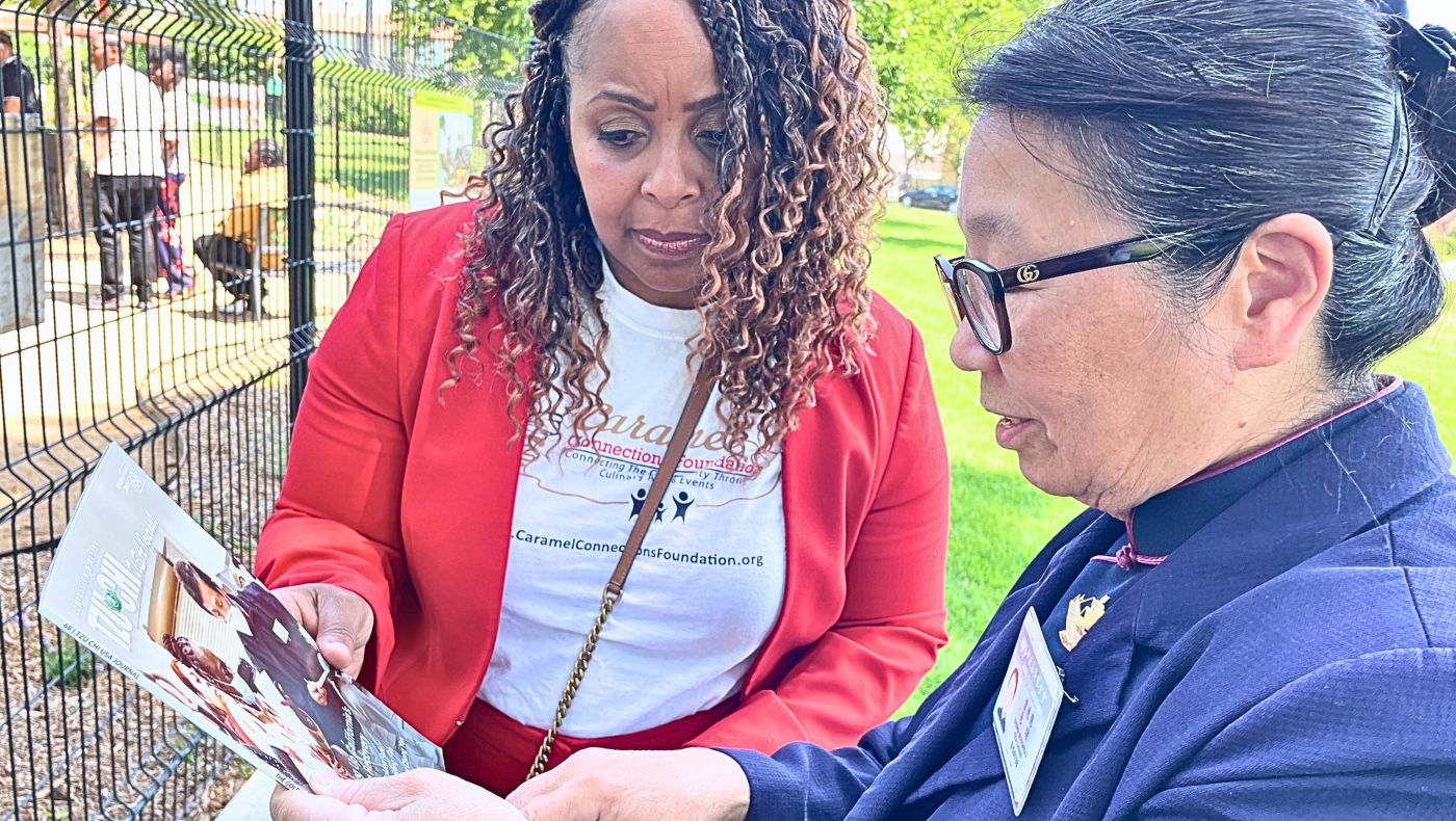 Debra Boudreaux, directora ejecutiva de de Tzu Chi USA, presenta el trabajo benéfico de Tzu Chi a Elizabeth McSwain (derecha), directora ejecutiva de la Fundación Caramel Connections. Foto/Jennifer Chien