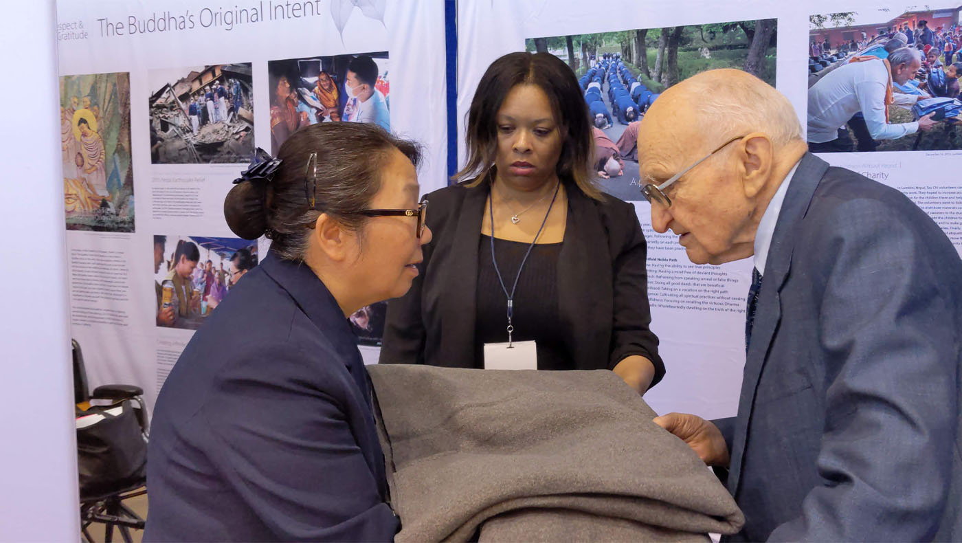 Tzu Chi USA CEO handing blanket to Blouke Carus