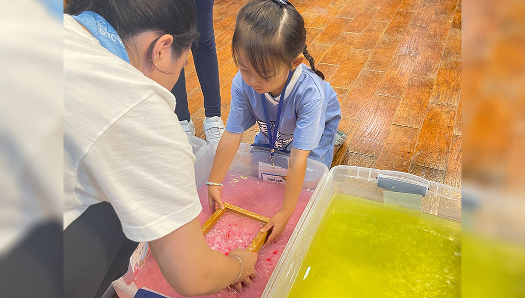 Tzu Chi collage students teaching young kid how to make handmade paper