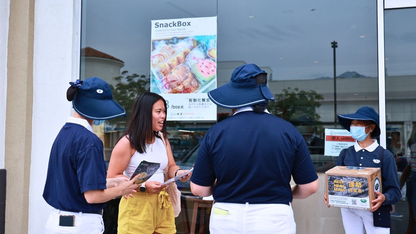 On August 19, Tzu Chi volunteers stand in front of a bakery holding a donation box and fundraising posters to collect donations from passersby. Photo/Shu Li Lo