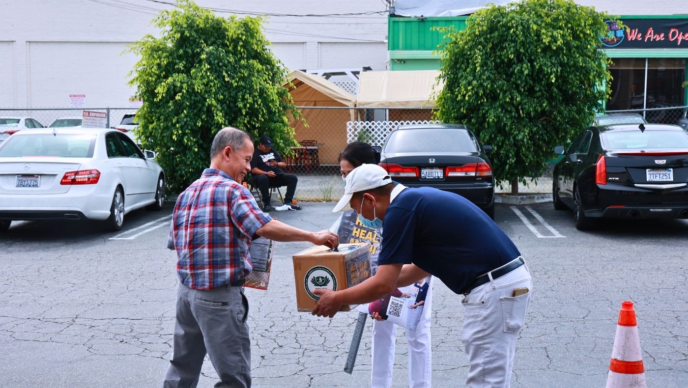 El 19 de agosto, los voluntarios de Tzu Chi recaudan donaciones frente a un supermercado. La gente  coloca dinero en la caja de recaudación. Foto/Shu Li Lo