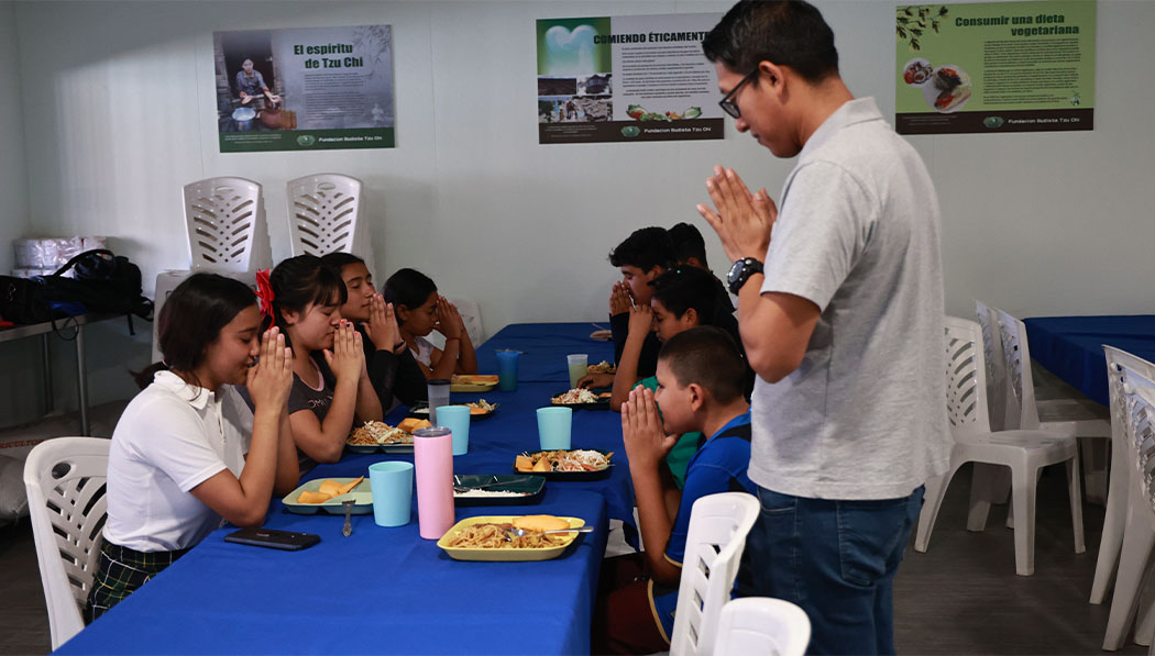 Teacher and students praying before meal
