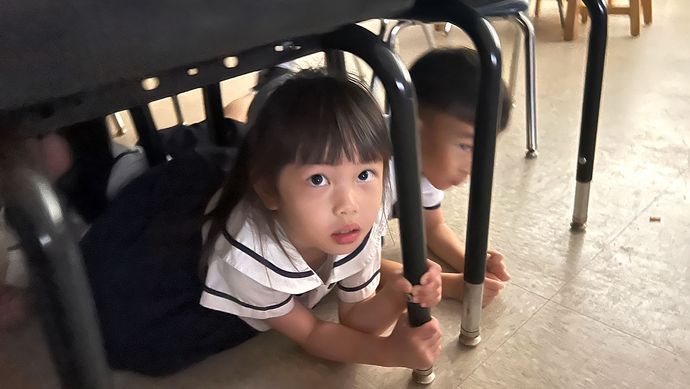 students hiding under the table